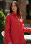 Woman wearing a red coat with gold buttons outdoors
